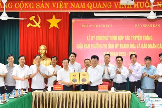 Phó Tổng Biên tập Báo Nhân Dân Quế Đình Nguyên và Phó Bí thư Thường trực Tỉnh ủy Thanh Hóa Lại Thế Nguyên trao nhau bản thỏa thuận hợp tác truyền thông giữa 2 cơ quan trước sự chứng kiến của lãnh đạo 2 đơn vị. (Ảnh: Thủy Nguyên)