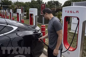 Người dân sạc điện cho ô-tô tại một trạm sạc của Tesla ở Arlington, Virginia, Mỹ. (Ảnh: AFP/TTXVN)