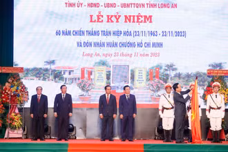 Chủ tịch nước Võ Văn Thưởng gắn Huân chương Hồ Chí Minh lên cờ truyền thống của tỉnh Long An. (Ảnh: Thống Nhất/TTXVN)