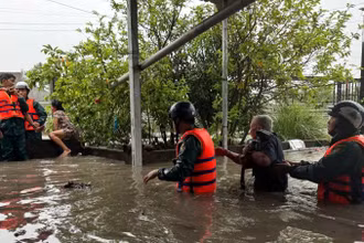 Lực lượng dân quân hỗ trợ người dân di dời khỏi khu vực bị ngập đến nơi an toàn.