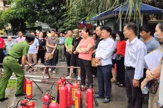 Lực lượng chức năng tập huấn kỹ năng phòng cháy, chữa cháy cho các tiểu thương. Ảnh: CHU DŨNG.