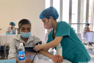 Các cán bộ y, bác sĩ thăm khám sức khỏe cho người dân trên địa bàn huyện Mê Linh.