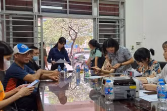 Những người dân chịu ảnh hưởng bởi vụ cháy nhận tiền hỗ trợ. (Ảnh: Việt Tuấn)
