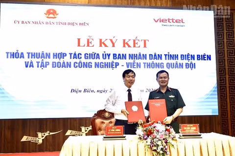 Đồng chí Lê Văn Lương, Chủ tịch Ủy ban nhân dân tỉnh Điện Biên và Trung tướng Tào Đức Thắng, Ủy viên Trung ương Đảng, Chủ tịch kiêm Tổng Giám đốc Tập đoàn Công nghiệp-Viễn thông Quân đội trao biên bản ký kết thỏa thuận hợp tác. (Ảnh: LÊ LAN)