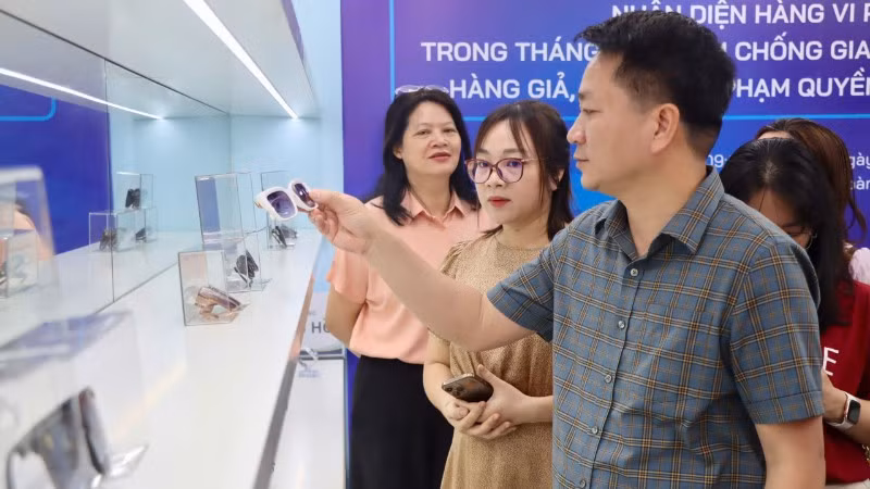 Phó Cục trưởng Quản lý và Phát triển thị trường trong nước (Bộ Công thương) Nguyễn Thanh Bình hướng dẫn người tham quan nhận diện kính mắt hàng giả.