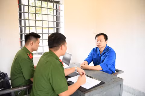 Điều tra viên lấy lời khai bị can Lê Đức Hùng. (Ảnh do Công an cung cấp)