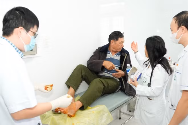 Các bác sĩ trong đoàn công tác trực tiếp xử trí một ca cấp cứu chấn thương bàn chân cho người.