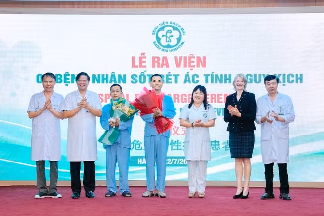 Hai bệnh nhân nhận hoa chúc mừng của thầy thuốc trước khi ra viện.