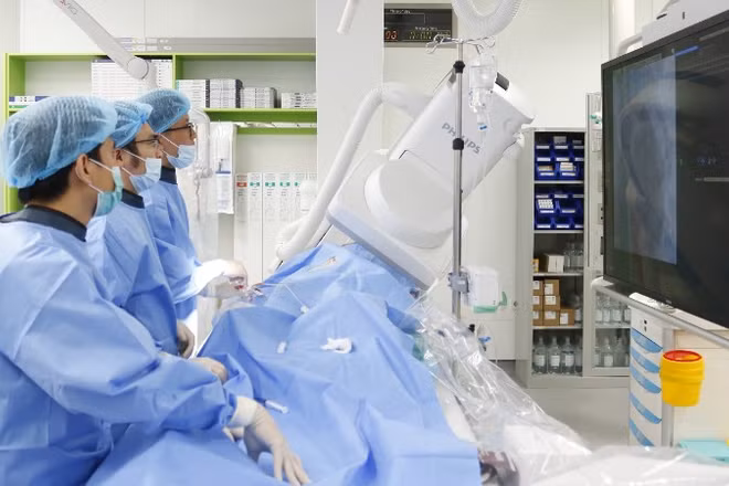 Ê kíp thực hiện kỹ thuật nút động mạch phế quản dưới hướng dẫn của hệ thống chụp mạch số hóa xóa nền.
