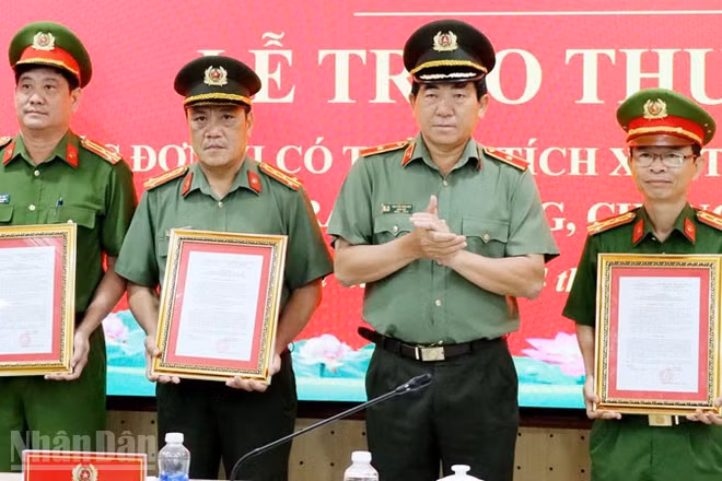 Thiếu tướng Nguyễn Văn Hận, Giám đốc Công an tỉnh An Giang trao quyết định khen thưởng cho các đơn vị. (Ảnh: TẤN AN).