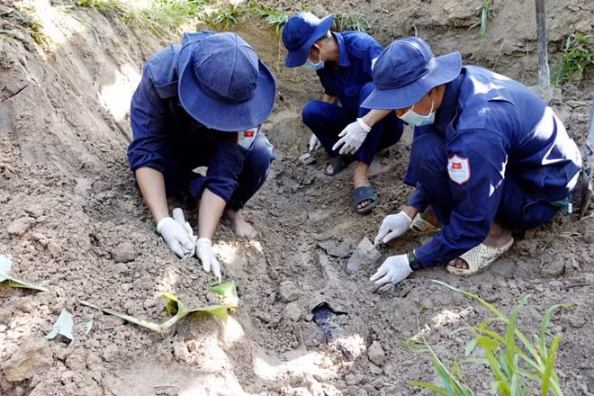Đội K92 cẩn trọng đào bới tìm kiếm hài cốt liệt sĩ tại ấp Rẫy Mới, xã Kiên Lương. (Ảnh: PHƯƠNG VŨ)