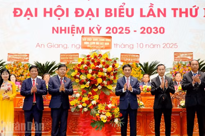 Thay mặt Bộ Chính trị, Đại tướng Phan Văn Giang tặng hoa của Ban Chấp hành Trung ương cho Đảng bộ tỉnh An Giang. (Ảnh: Ban tổ chức Đại hội cung cấp)