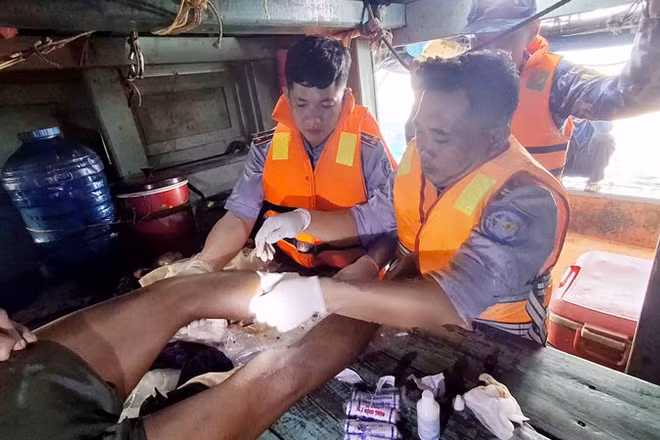 Cán bộ, chiến sĩ Cảnh sát biển tiến hành băng bó vết thương và cầm máu cho ngư dân gặp nạn. (Ảnh: Bộ Tư lệnh Vùng Cảnh sát biển 4)