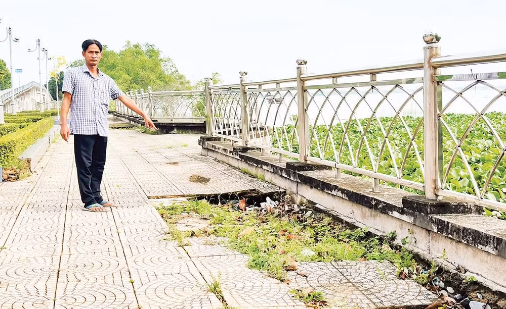 Người dân chỉ nơi sụt lún kè sông Cổ Chiên đoạn phường Tân Ngãi, tỉnh Vĩnh Long.