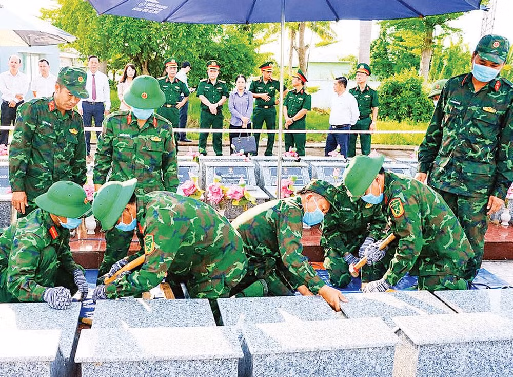 Lực lượng chuyên môn tiến hành lấy mẫu ADN đối với những phần mộ chưa xác định được thông tin tại Nghĩa trang liệt sĩ Châu Thành, xã Phú Hựu, tỉnh Đồng Tháp (Ảnh VIỆT TIẾN)