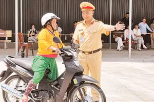 Cán bộ Đội Sát hạch cấp giấy phép lái xe cơ giới đường bộ, Phòng Cảnh sát giao thông, Công an tỉnh Tuyên Quang hướng dẫn người dân thi sát hạch giấy phép lái xe mô-tô.