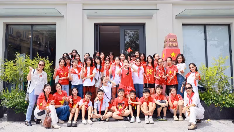 Các em học sinh chụp ảnh lưu niệm tại mô hình cột mốc Trường Sa ở Trung tâm Thông tin văn hóa Hồ Gươm.