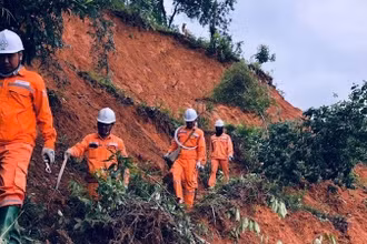 Công nhân Công ty Điện lực Điện Biên đi bộ vượt núi khắc phục sự cố do lũ quét.