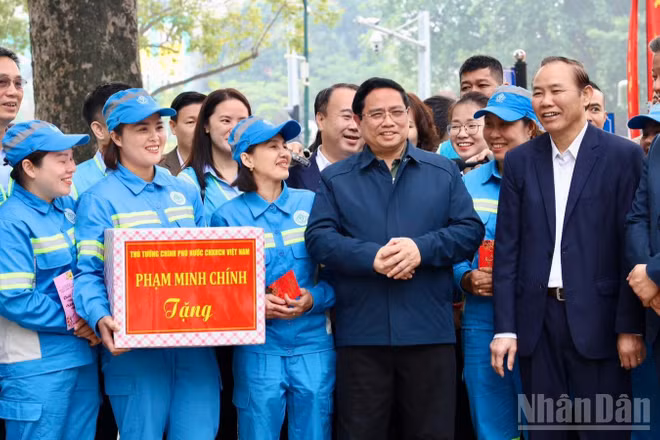 Thủ tướng Chính phủ Phạm Minh Chính thăm, động viên, chúc Tết đội ngũ công nhân vệ sinh môi trường của Công ty URENCO tại Vườn hoa Lê Trực. (Ảnh: Hải Linh)