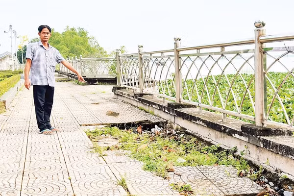 Người dân chỉ nơi sụt lún kè sông Cổ Chiên đoạn phường Tân Ngãi, tỉnh Vĩnh Long.