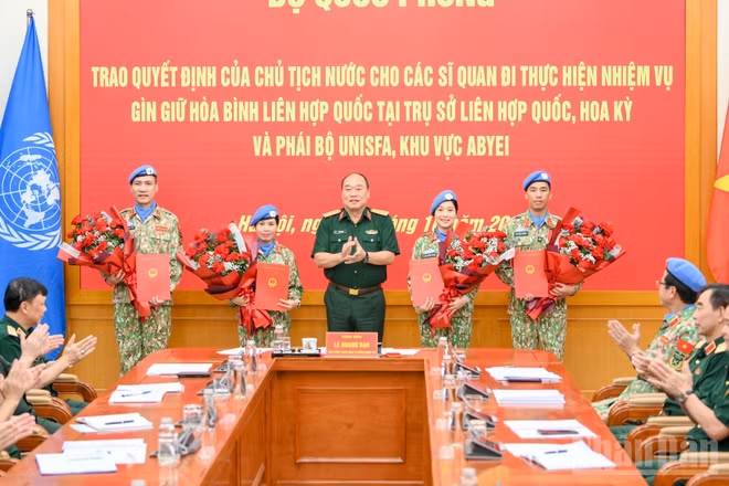 Thượng tướng Lê Quang Đạo trao quyết định cho 4 sĩ quan Quân đội nhân dân Việt Nam đi thực hiện nhiệm vụ gìn giữ hòa bình Liên hợp quốc. (Ảnh: THẾ ĐẠI)