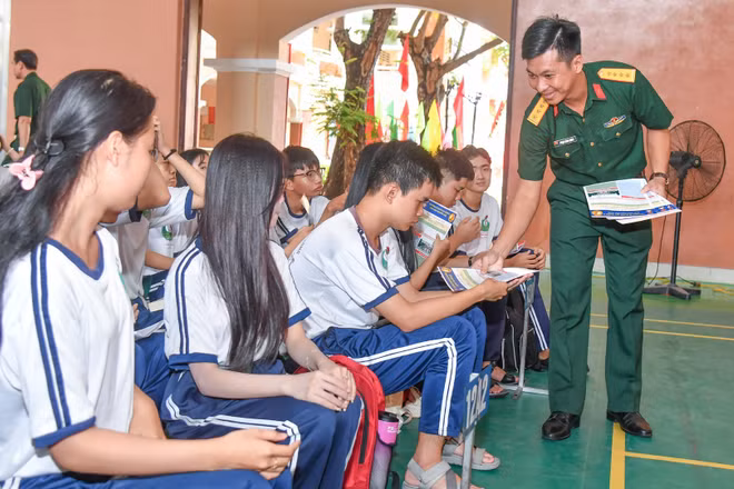 Cán bộ tuyển sinh phát tờ rơi những thông tin cần biết về tuyển sinh quân sự 2026.