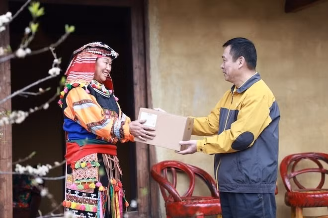 Nhân viên bưu điện chuyển phát bưu phẩm đến tay người dân.