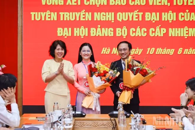 Đồng chí Nguyễn Thị Hoàng Vân, Phó Bí thư Đảng ủy các cơ quan Đảng Trung ương tặng hoa chúc mừng 2 báo cáo viên, tuyên truyền viên được chọn tham dự Hội thi báo cáo viên, tuyên truyền viên giỏi toàn quốc năm 2026 khu vực phía bắc. (Ảnh: BẢO LONG)