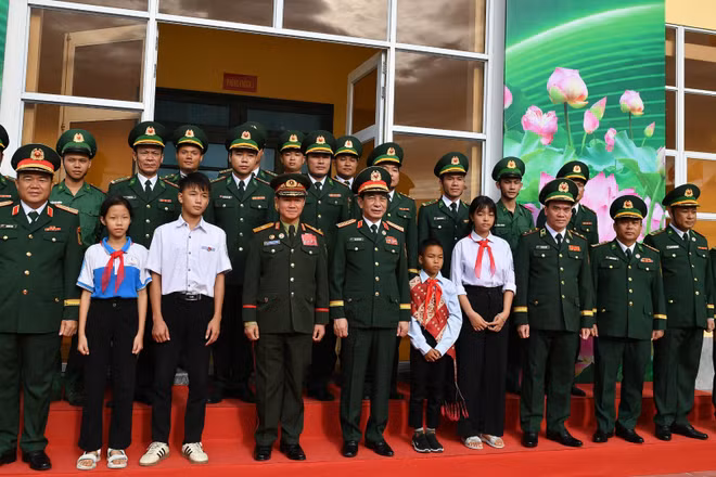 Đại tướng Phan Văn Giang và Đại tướng Khamliang Outhakaysone, các đại biểu, các em học sinh cùng cán bộ, chiến sĩ Đồn Biên phòng Cửa khẩu Thanh Thủy chụp ảnh lưu niệm.