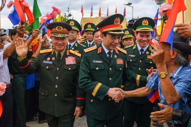 Bà con nhân dân biên giới chào mừng hai Phó Thủ tướng, Bộ trưởng Quốc phòng Việt Nam-Lào đến dự lễ sơ kết kết nghĩa cụm dân cư hai bên biên giới.