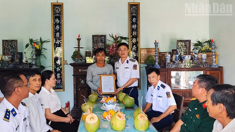 Đại tá Nguyễn Tiến Đức trao quyết định phụng dưỡng Mẹ Việt Nam Anh hùng Lâm Thị Hoạnh. (Ảnh: NAM TRUNG)