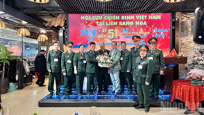 Chủ tịch Liên hiệp các tổ chức người Việt Nam tại Liên bang Nga Đỗ Xuân Hoàng tặng hoa chúc mừng Hội Cựu chiến binh Việt Nam tại Liên bang Nga. (Ảnh: XUÂN HƯNG)