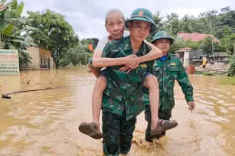 Bộ đội Biên phòng Tam Quang cõng đưa một cụ ông đến nơi an toàn. (Ảnh: HẢI THƯỢNG)