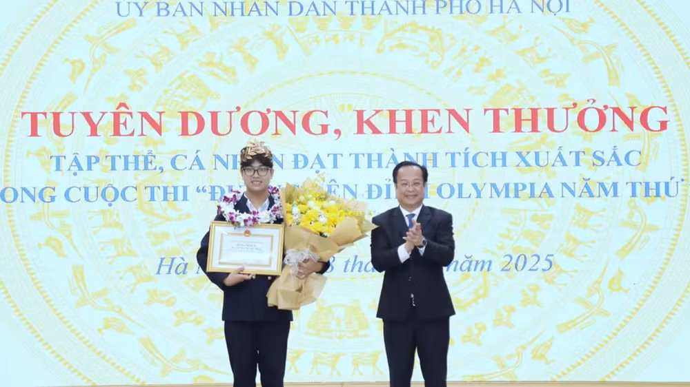 Giám đốc Sở Giáo dục và Đào tạo Hà Nội Trần Thế Cương chúc mừng Trần Bùi Bảo Khánh (Ảnh: Sở Giáo dục và Đào tạo Hà Nội)