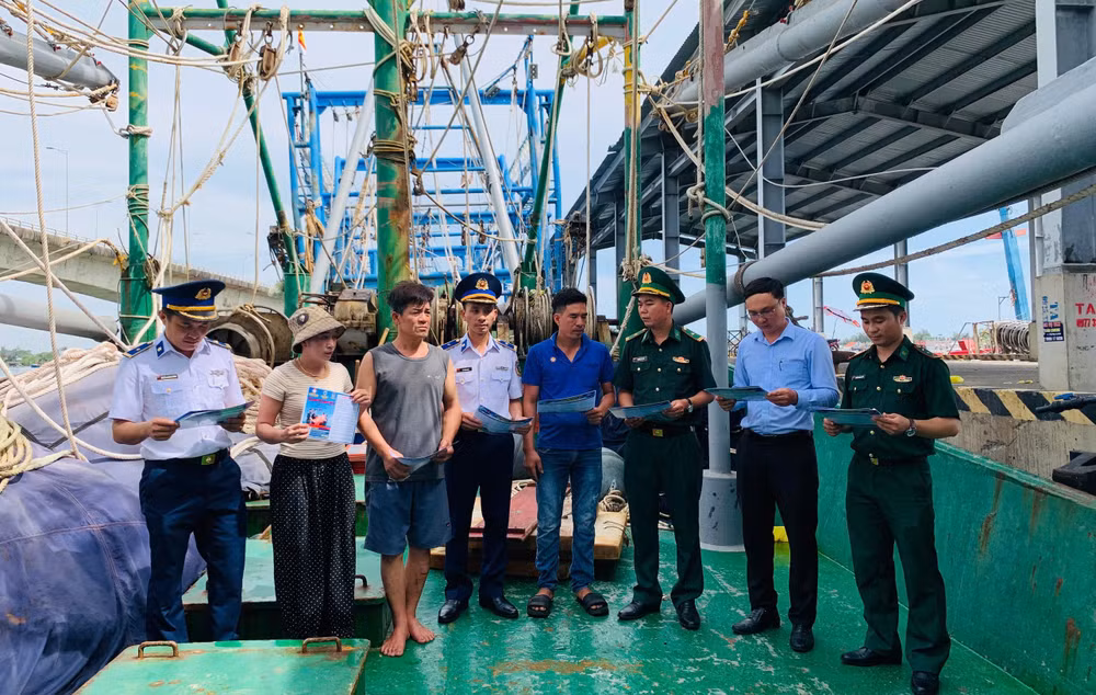 Các đơn vị tuyên truyền, phát tờ rơi trên các tàu cá đang neo đậu tại Cảng Nam Cửa Việt. (Ảnh: XUÂN THẾ).