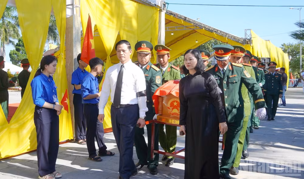 Các đại biểu tiễn đưa các liệt sĩ về nơi an nghỉ. (Ảnh: H.M)