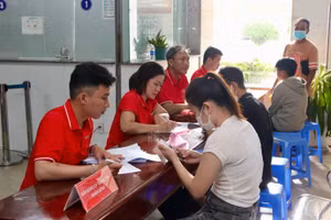 Cán bộ nhân viên Viettel địa phương hỗ trợ người dân đăng ký thông tin khám sàng lọc. (Ảnh: TRẦN LONG)
