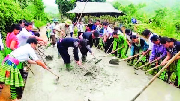 Đồng bào H’Mông xã Hưng Khánh tham gia đổ bê-tông làm đường giao thông nông thôn.