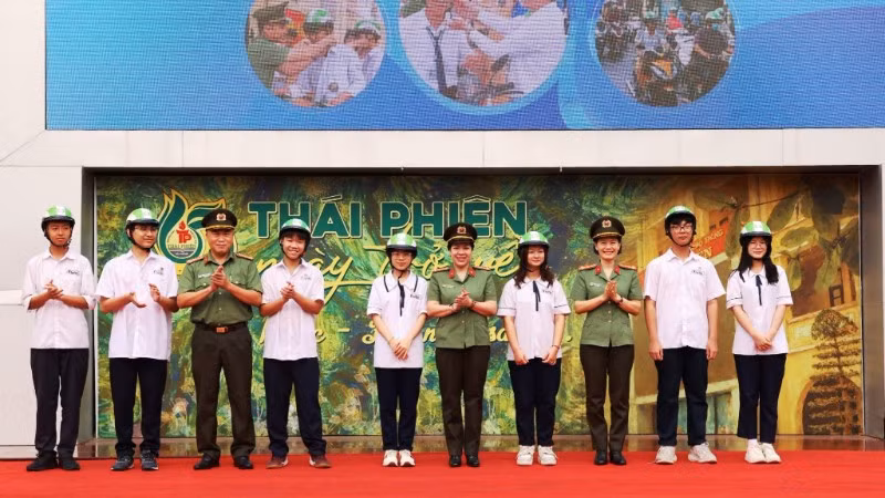 Ban tổ chức chương trình tặng mũ bảo hiểm cho các em học sinh Trường trung học phổ thông Thái Phiên.