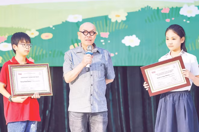 Họa sĩ Thành Chương chia sẻ niềm vui với các tác giả nhí nhận Giải thưởng Thiếu nhi Dế Mèn. (Ảnh: MAI AN)