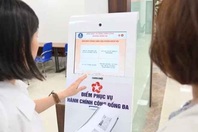 Cán bộ hướng dẫn người dân làm thủ tục hành chính tại Điểm phục vụ hành chính công phường Đống Đa (Thành phố Hà Nội). (Ảnh: THẾ ĐẠI)