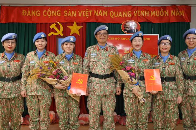 Trung tá, bác sĩ Trần Đức Tài (người đứng giữa), Bí thư Đảng ủy, Giám đốc Bệnh viện dã chiến cấp 2 số 7 và các đồng chí đảng viên Khoa Khám bệnh chúc mừng 2 đảng viên mới. (Ảnh: TIẾN PHÚC)
