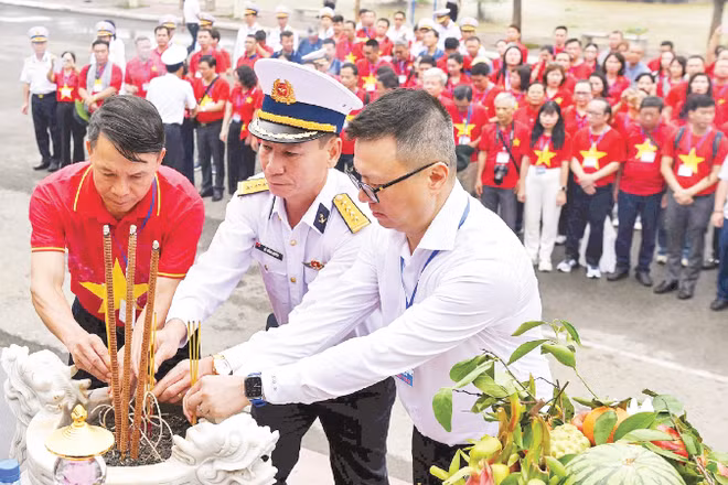 Đồng chí Lê Quốc Minh, Tổng Biên tập Báo Nhân Dân và lãnh đạo Đoàn công tác số 25 cùng đội ngũ những người làm báo dâng hương tại Tượng đài tưởng niệm các chiến sĩ Đoàn tàu không số anh hùng. (Ảnh: ĐỨC NGHĨA)