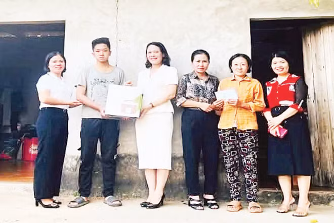 Thầy, cô giáo Trường trung học phổ thông Tam Đảo trao quà, đồ dùng học tập tặng em Trần Văn Thiên.