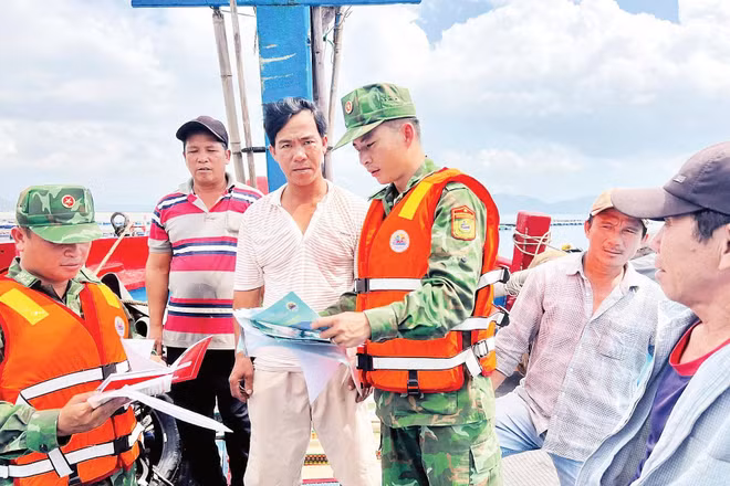 Cán bộ, chiến sĩ Đồn Biên phòng An Hải trao đổi trực tiếp với ngư dân về các thủ tục, giấy tờ liên quan chuyến biển.