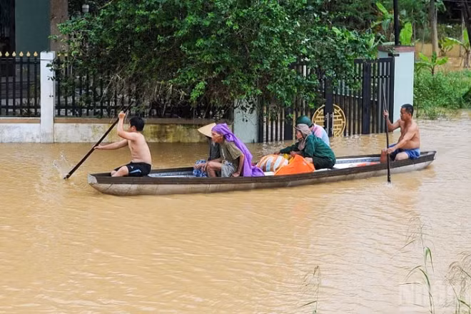 Người dân xã Đại Lộc sử dụng thuyền để di chuyển vì mưa lũ. (Ảnh: CÔNG VINH)