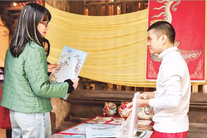 Du khách tìm hiểu về ý nghĩa của hoa văn qua những sản phẩm do Bối Ân phối hợp các làng nghề truyền thống sản xuất. (Ảnh NVCC)