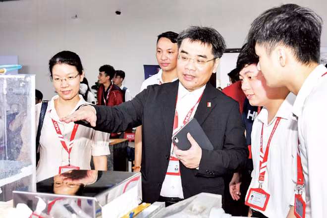 Lãnh đạo Đại học Bách khoa Hà Nội trao đổi với sinh viên về sản phẩm nghiên cứu khoa học tại một triển lãm.