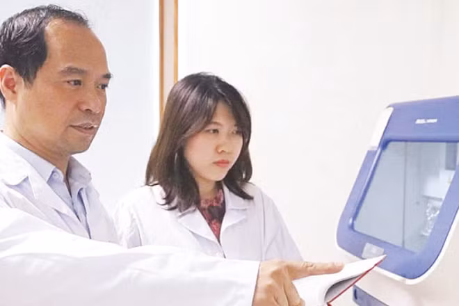 Giáo sư, Tiến sĩ Nguyễn Huy Hoàng hướng dẫn đồng nghiệp kiểm tra kết quả ứng dụng công nghệ WES phân tích gen mã hóa protein trên hệ gen người.(Ảnh: MINH ĐỨC)
