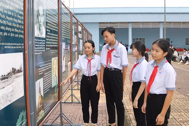 Học sinh xã Trung Thành, tỉnh Vĩnh Long xem triển lãm ảnh với chủ đề kỷ niệm 85 năm Ngày Khởi nghĩa Nam Kỳ.